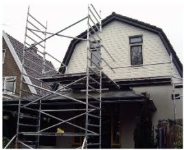 Woning met een steiger voor het buitenschilderwerk aan de voorgevel
